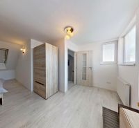 Interior of a 3-room apartment with a bed, windows, and a floor with a wooden decor.
