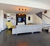 Interior of a 3-room apartment with red chairs and a wooden decor floor.