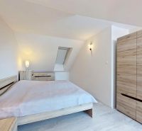 A bedroom with a bed and a wardrobe with a wood decor in a 3-room apartment.