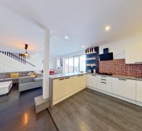 Open floor plan in a 3-room apartment with a kitchen, living room, and wooden decor flooring.