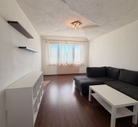 Living room in a 3-room apartment with a wooden decor floor and a corner sofa.