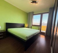 A bedroom in a 3-room apartment with a wood-decor floor and green walls.