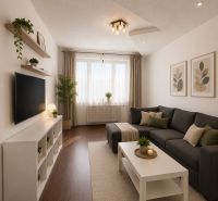 Living room in a 3-room apartment with a wooden decor floor, gray sofa, and white furniture.