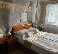 A bedroom with a double bed and oriental decorations in a three-room apartment.
