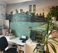 A workspace with a desk, plants, and decorative wallpaper in a 3-room apartment.