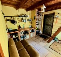 The interior of the cottage with a rustic kitchenette and wooden ceiling creates a cozy space.