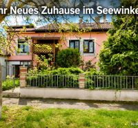 A family house in Illmitz with a pink facade and a green front garden full of plants.