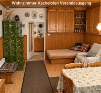 Living room of a family house with a tiled stove and wooden decor.