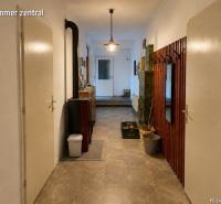 A hallway in a family house with a coat rack, mirror, and stove, and a floor with a wooden decor.