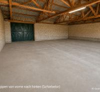 A spacious garage with an exposed roof structure and a concrete floor in a family house.