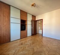 A room in a 4-room apartment with a wood-patterned floor and a built-in wardrobe.