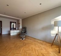 Living room in a 4-room apartment with a wooden decor floor and a comfortable armchair.