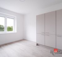 A room in a 3-room apartment with a wooden decor floor and a wardrobe.