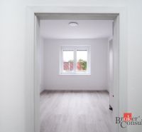 A spacious room with a wooden decor floor in a 3-room apartment.