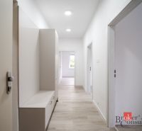 A bright hallway in a 3-room apartment with wood-patterned flooring and furniture.