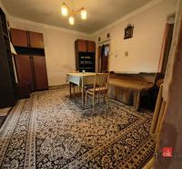 The interior of a family house with a carpet, wooden table, and cabinets.