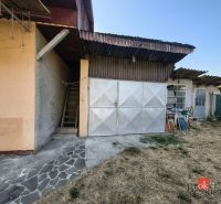 A family house in Ladice with a metal garage and a stone walkway.