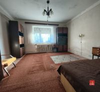 A bedroom in a family house with carpet and older furniture.