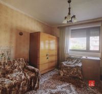 A room in a family house with furniture, wallpaper, and carpet.
