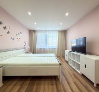 A bright bedroom with butterflies on the wall and a wooden decor floor in a 2-room apartment.