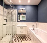 Bathroom in a 2-room apartment with a shower, bathtub, and white tiles.