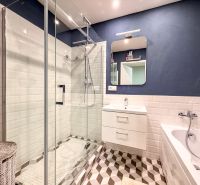 A bathroom in a 2-room apartment with a bathtub, shower, and designer tiles.