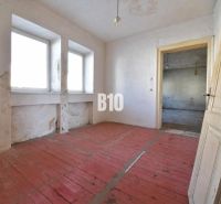 A room in a family house with a wooden floor and simple furnishings.