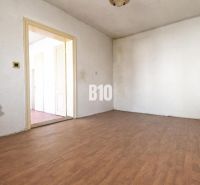A room in a family house with white walls and a wooden decor floor.