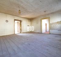 A spacious room with a wooden decor floor in a family house, suitable for renovation.