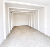 The interior of a spacious garage with white walls and a concrete floor.
