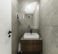 Bathroom with a sink on a wooden cabinet and gray tiles in a 3-room apartment.