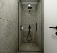 A shower corner with dark tiles and elegant black fixtures in a 3-room apartment.