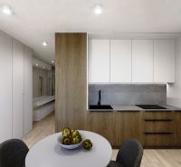 Kitchen area in a 3-room apartment with a wooden decor floor and white cabinets.