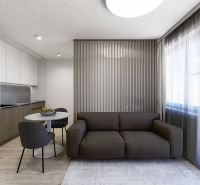 Living area of a 3-room apartment with a sofa and a dining table, floor with wooden decor.