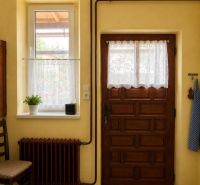Yellow walls, wooden door, window with white curtains in a family house.