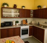Kitchen of a family house with wooden cabinets, table, and decorations.