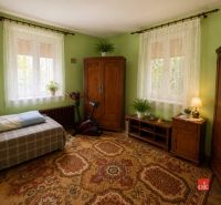 Green walls, carpet, wooden furniture, and an exercise bike in a family house.