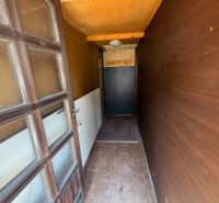 A narrow hallway with a wooden wall and carpet in a family house.
