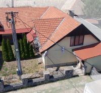 A family house in Dobrá Niva with a red roof, a garden, and trees.