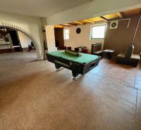 Interior of a family house with a pool table and brick arches.