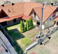 A family house in the village of Dobrá Niva with a red roof and a yard surrounded by a fence.