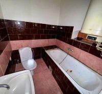 A bathroom in a family house with tiles in shades of pink and brown.