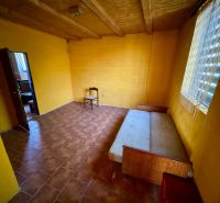 A room in a family house with a wooden decor floor and yellow walls.