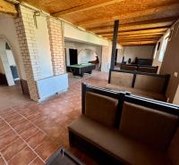 The interior of a family house with a billiard table and brick arches.