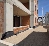 Construction of a 3-room apartment in SRIMA, with an exposed brick facade and a gravel courtyard.