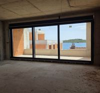 Unfinished interior of a 3-room apartment with a sea view and a balcony.