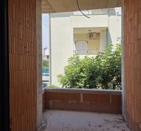 Unfinished balcony in a 3-room apartment with a view of greenery and the adjacent building.