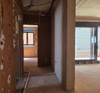 Unfinished interior of a 3-room apartment with large glass doors and masonry.