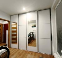 Bedroom with a wardrobe and bicycles in a 3-room apartment; floor with wood decor.