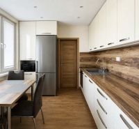 A kitchen in a 3-room apartment with a floor and countertop featuring a wood design.